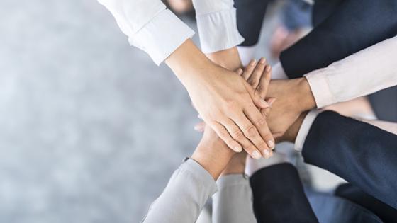 multiple hands stacked on top of each other